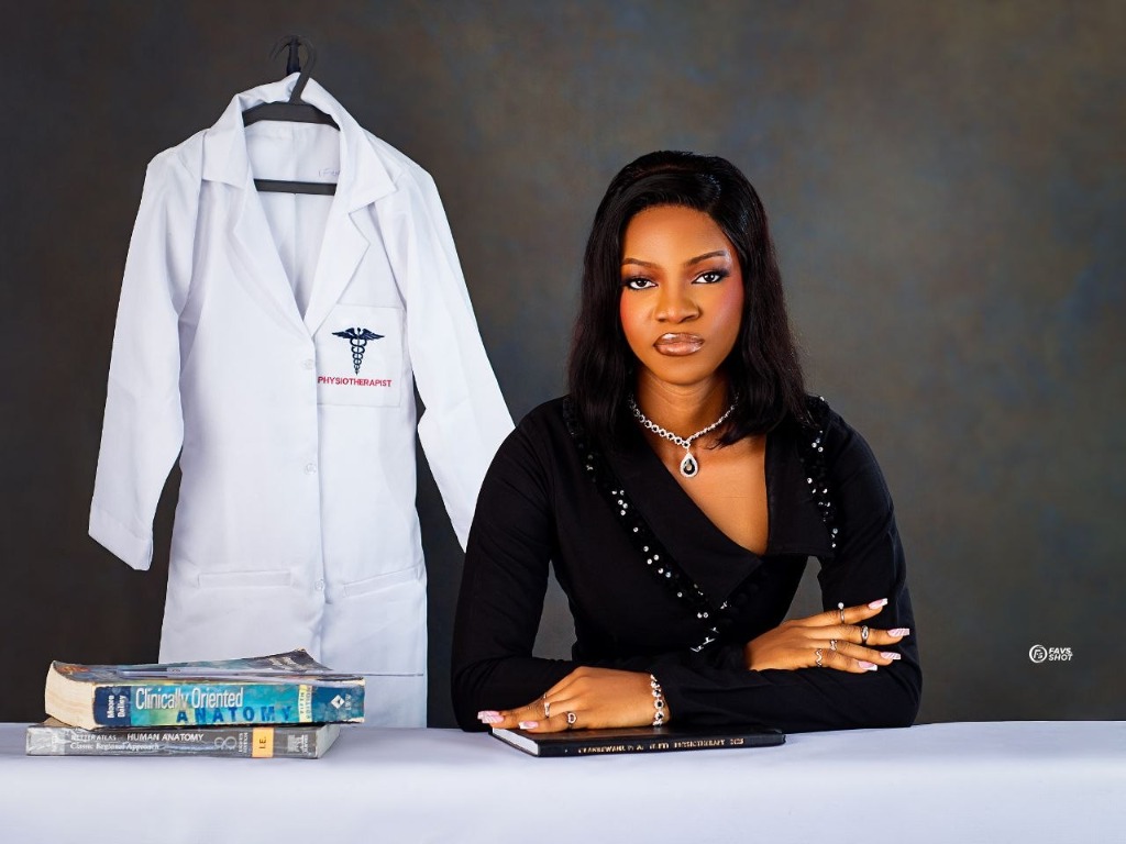 Physiotherapy graduate with lab coat and books