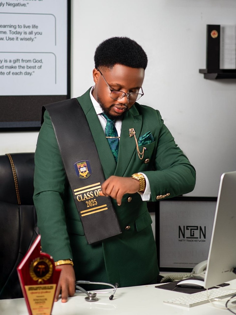 Graduate in green suit at office desk